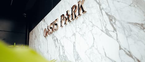 A marble wall with the text "Oasis Park" in a bold, modern font.