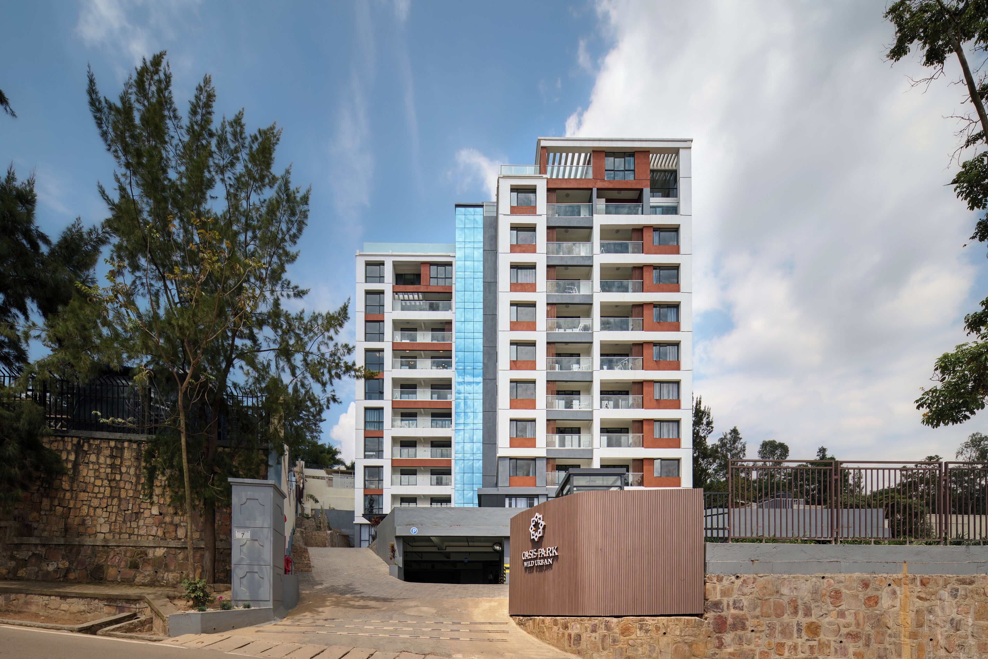 A multi-story residential building with balconies and a parking garage entrance.