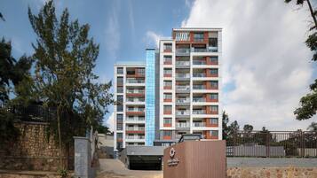 Un edificio residencial de varios pisos con balcones y la entrada a un estacionamiento.