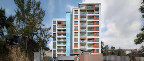 A multi-story residential building with balconies and a parking garage entrance.