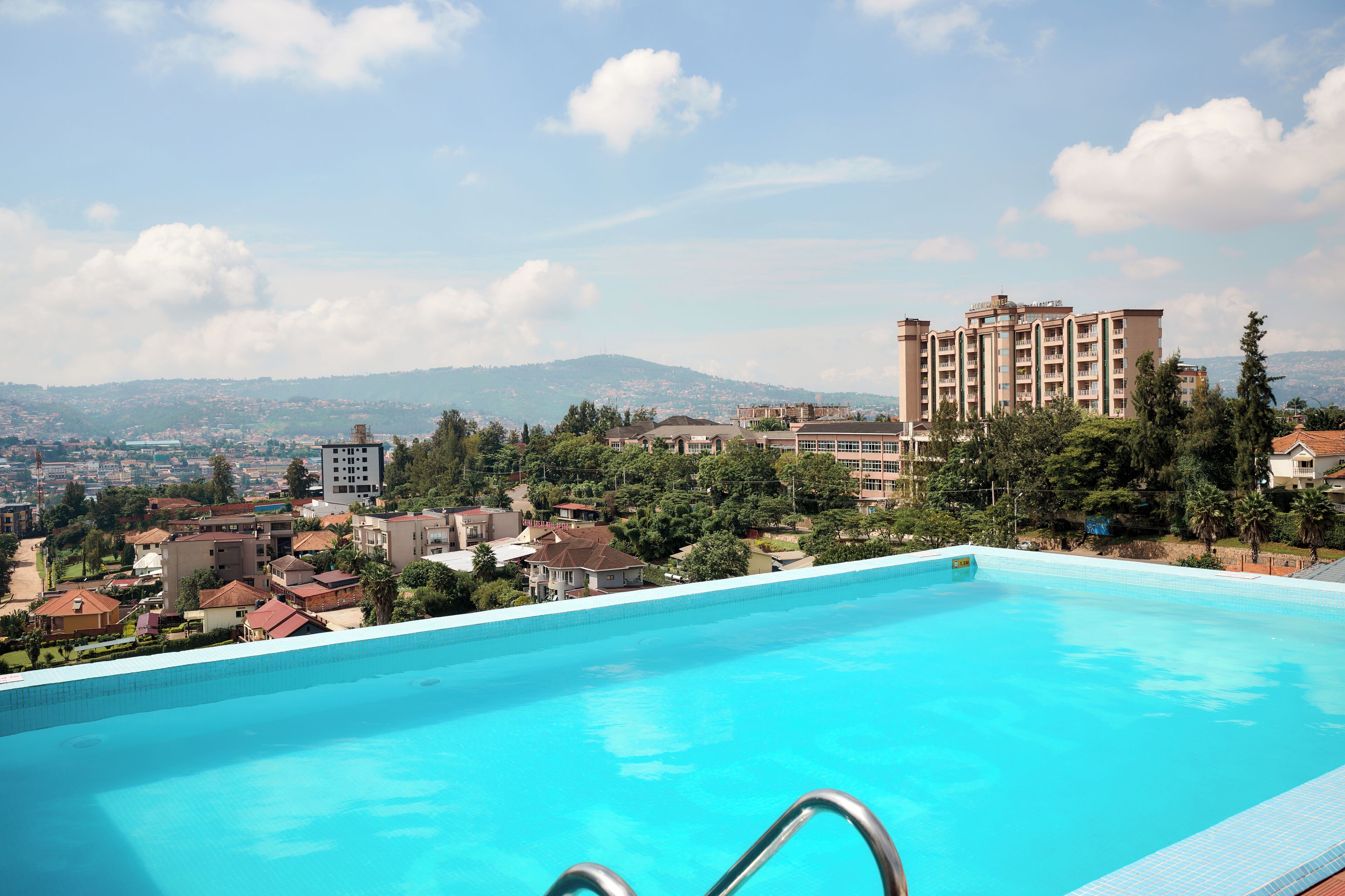 A swimming pool with a view of a cityscape and mountains in the background.