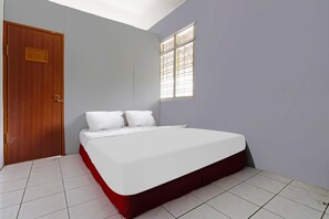Een slaapkamer met een bed, een houten deur en een raam.