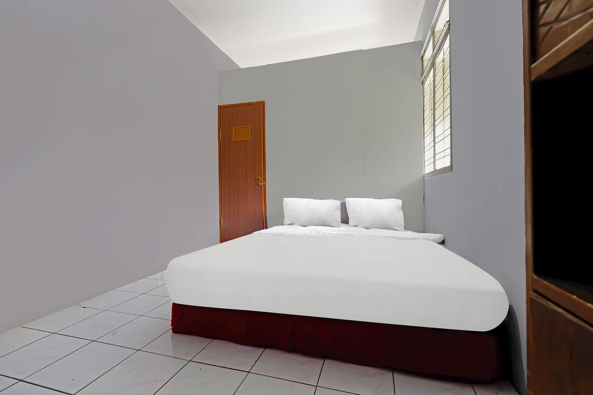 Een slaapkamer met een bed, een deur en een raam.