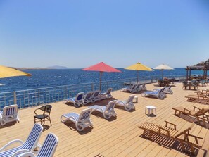 A deck with sun loungers and umbrellas, overlooking the ocean. - Jewel Sharm El Sheikh Hotel (Sharm El Sheikh)