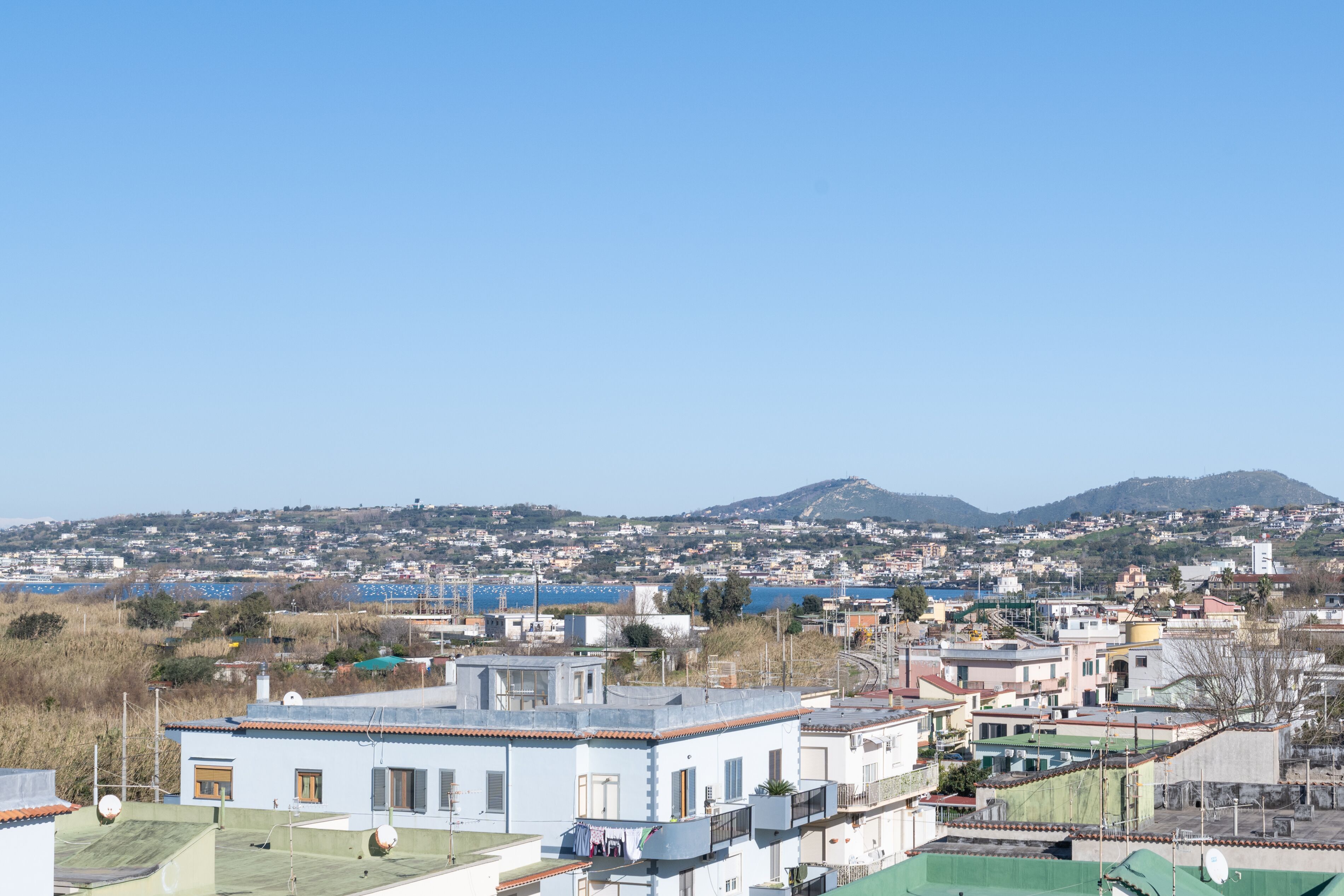 Un quartier résidentiel avec des maisons, un ciel dégagé et une montagne qui se profile à l’horizon.