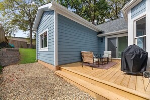 Eine Terrasse mit Grill und Gartenmöbeln.