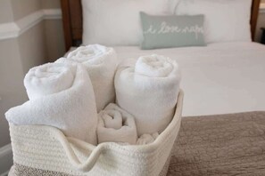 Ein Bett mit weißer Decke und einem Kopfkissen mit dem Aufdruck "Ich liebe dich".