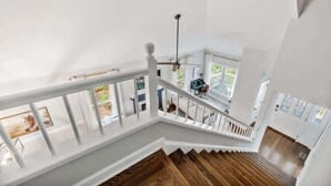 A spacious interior with a wooden staircase leading to a second floor.