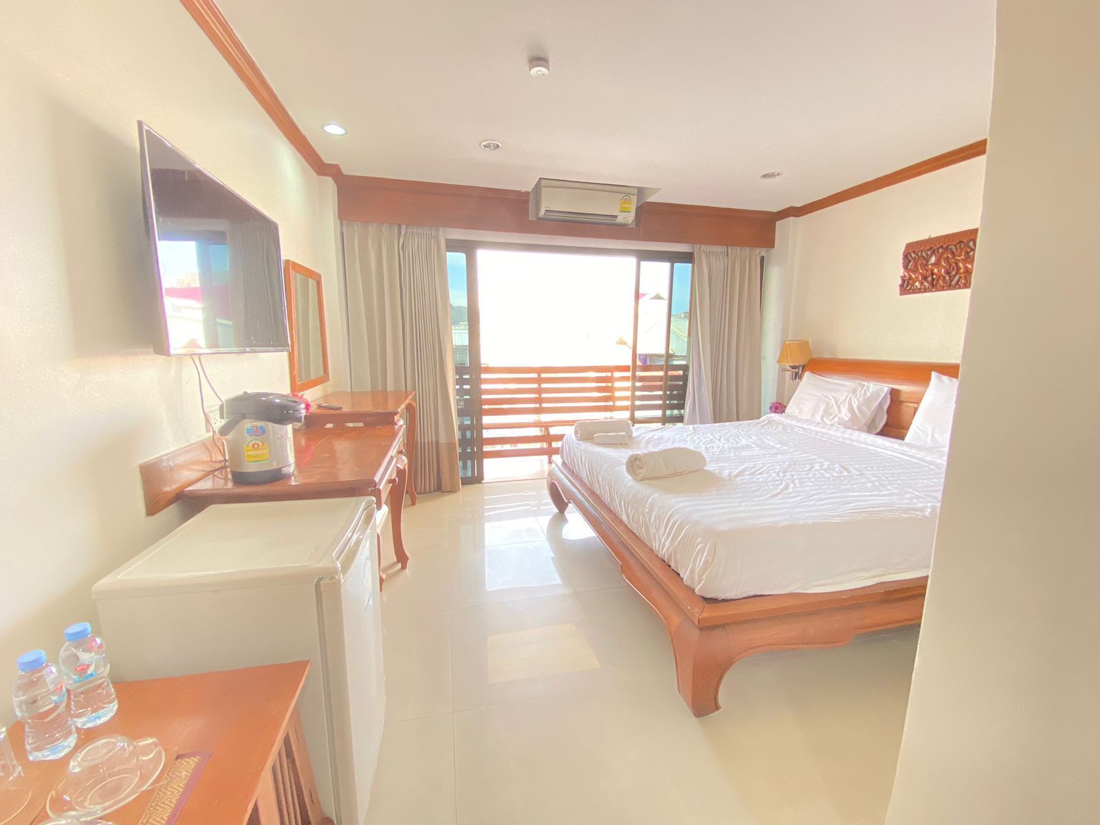 A hotel room with a bed, a desk, a chair, a television, and a window with curtains.