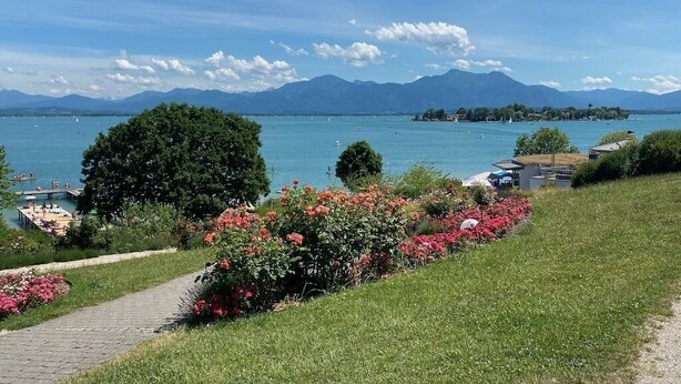 Une vue sur le lac, avec un ciel dégagé, des montagnes en arrière-plan et un sentier menant à un quai.