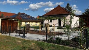 A residential area with houses, a fenced garden, and a bench. - Ferienhaus Albertus (Cottbus)