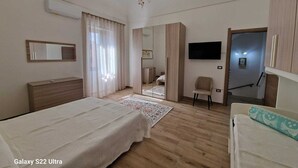 Een slaapkamer met een bed Galaxy S22 Ultra, een kroonluchter, een televisie en een spiegel.
