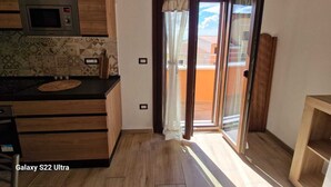 Een moderne keuken met een magnetron, houten kastjes en een decoratieve spatwand.