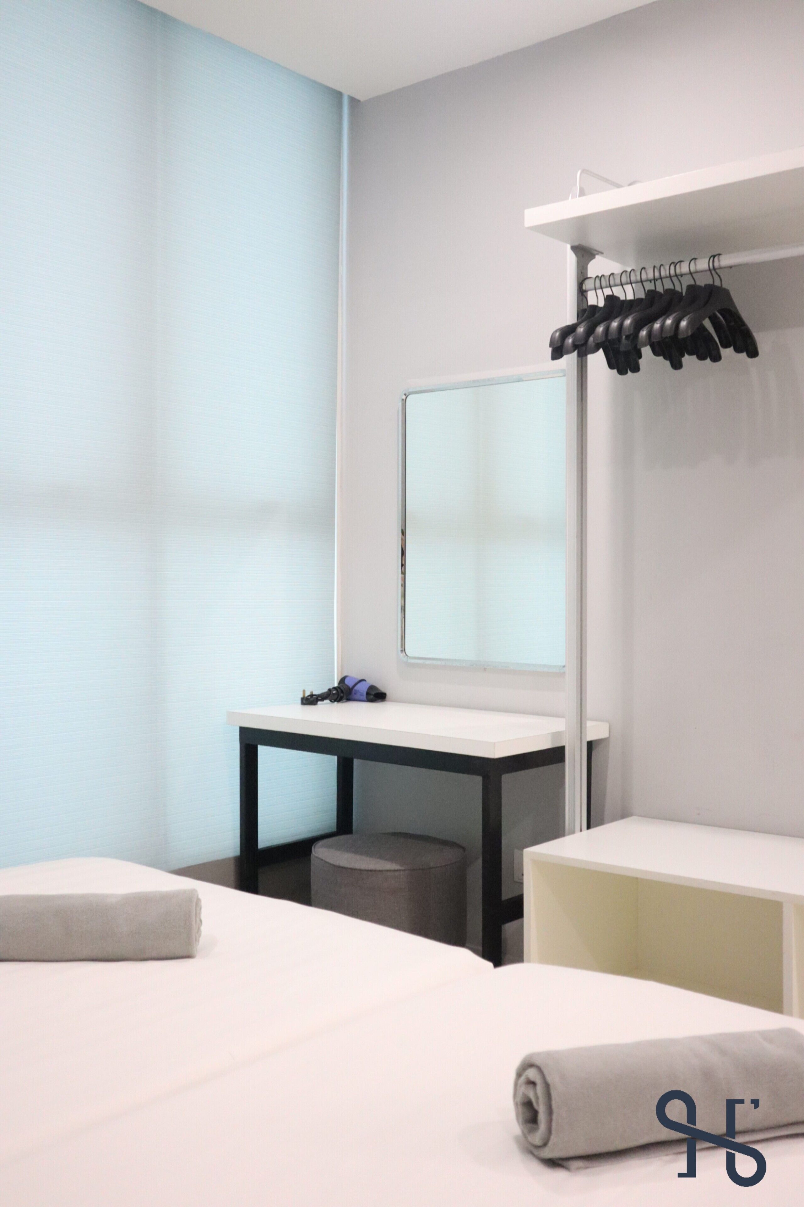 Une chambre d’hôtel avec un lit, un bureau et un miroir.