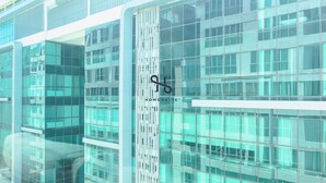 A modern building with large glass windows and a vertical metal structure. - Homesuite' Home at Sutera Avenue (Kota Kinabalu)