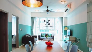 A modern living room with a dining area, a ceiling fan, and a large window providing natural light. - Homesuite' Home at Sutera Avenue (Kota Kinabalu)