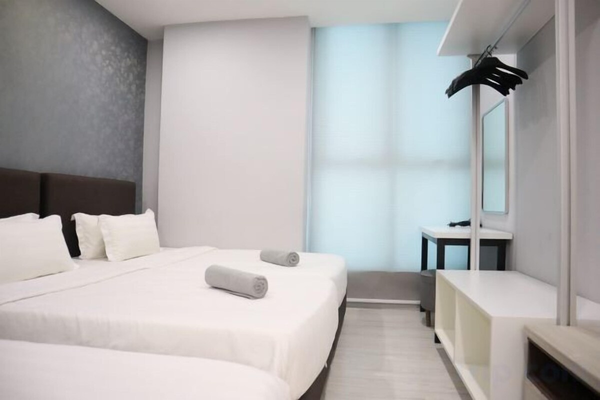 Een moderne hotelkamer met een groot bed, een nachtkastje, een spiegel en uitzicht op de lucht.