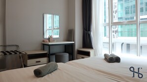 A hotel room with a bed, a desk, a chair, a small table, and a window with curtains. - Homesuite' Home at Sutera Avenue (Kota Kinabalu)