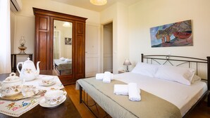Ein ordentlich eingerichtetes Hotelzimmer mit Bett, Nachttisch und einem Bild an der Wand.