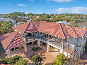 A two-story house with a red-tiled roof, a covered patio, and a view of the surrounding neighborhood.