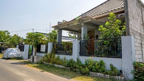 A residential house with a tiled roof, a covered porch, and a gated entrance. - SPOT ON 93210 Griya Kos Kanjeng Mami Syariah (Jogoroto)