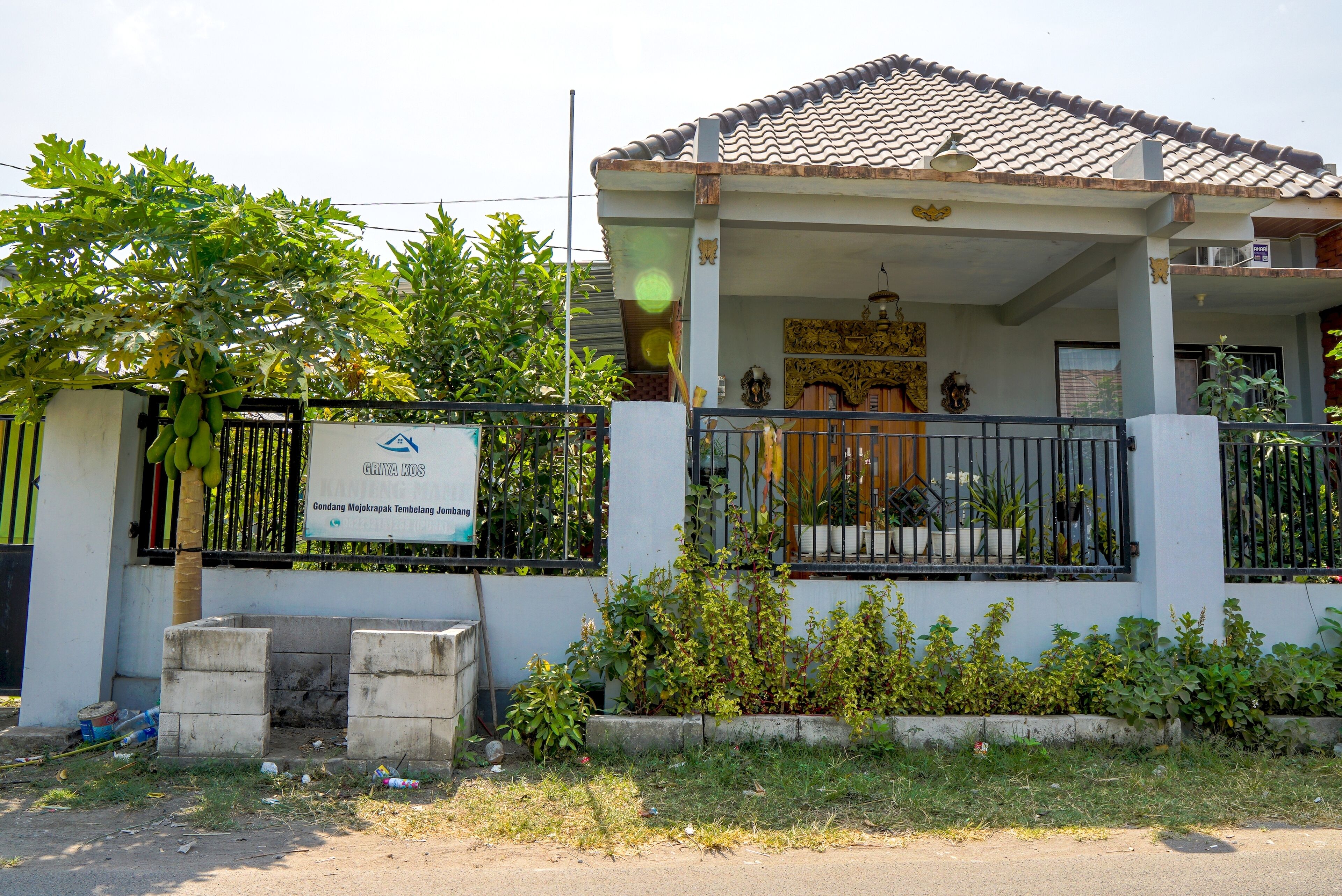 A building with a tiled roof, a balcony, and a signboard.