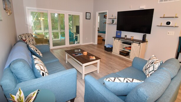 A living room with a sofa set, a coffee table, and a flat-screen TV.