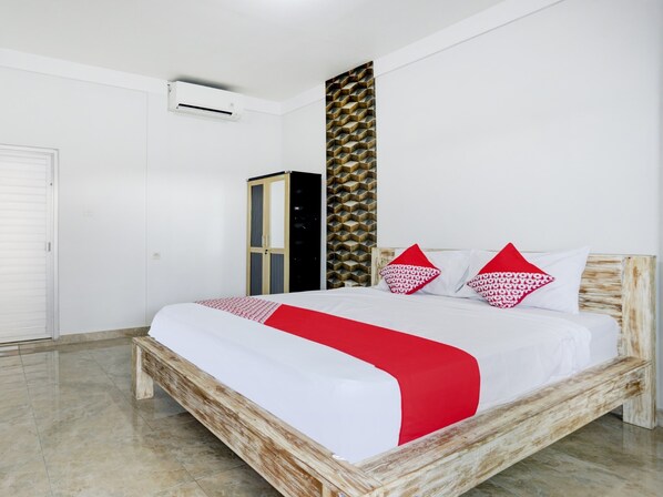 Une chambre à coucher comprenant un lit, une armoire et un climatiseur fixé au mur.