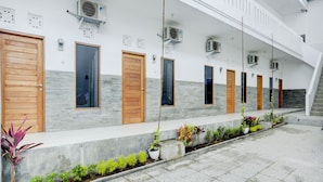 A modern building with multiple doors and air conditioning units. - OYO Flagship 90756 Melasti Hills Room & Cafe (Ungasan)