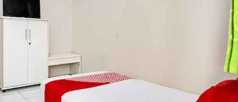 A small, clean room with a bed, a white wardrobe, and a desk.