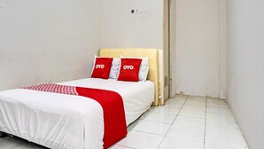 A small, clean room with a bed, white walls, and a tiled floor. - OYO Life 92684 Kost Mutiara Nirwana (Karawang)