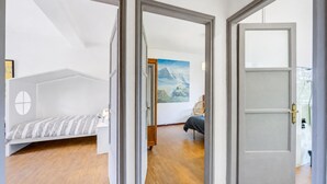 Ein Zimmer mit einem Bett, einem Sessel und einem Bild an der Wand.