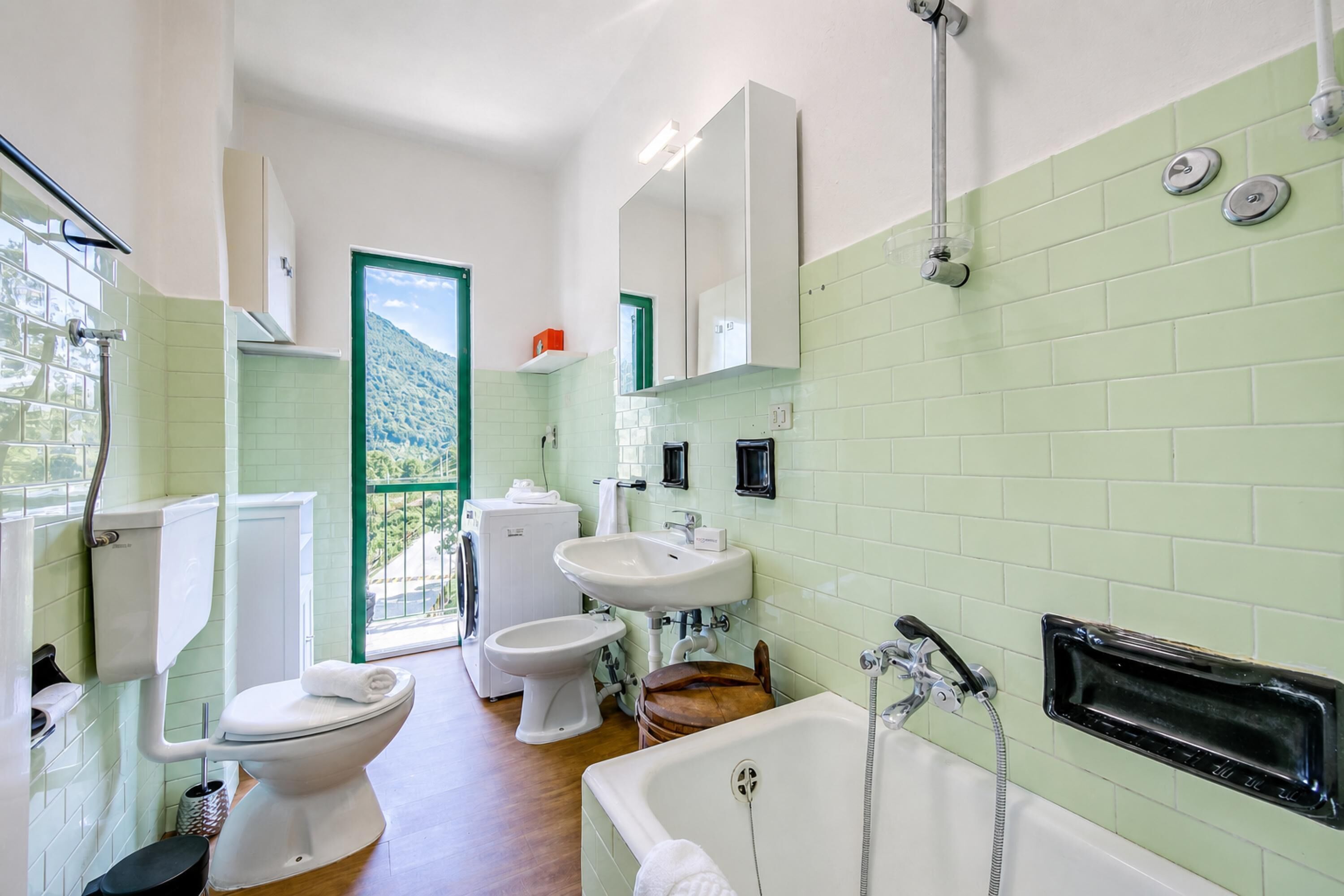 A bathroom with a toilet, bidet, sink, and bathtub.