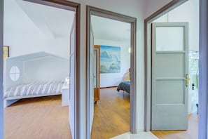 Una habitación con una cama, una silla y un cuadro en la pared.