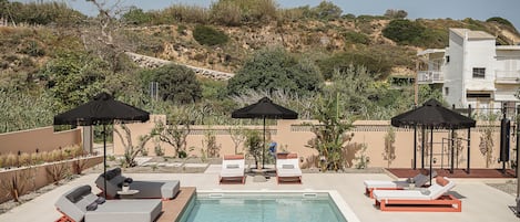 Outdoor pool, a heated pool, pool umbrellas, pool loungers