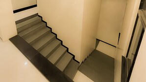 Una escalera de diseño moderno, con un borde negro y una pared de color claro.