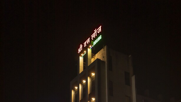 Un hotel con un letrero que indica que ofrece alojamiento, cocina vegetariana punjabi y una zona de descanso familiar.