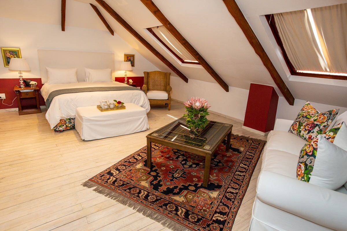 Ein Schlafzimmer mit einem Bett, einem Schlafsofa, einem Couchtisch und einer roten Akzentwand.