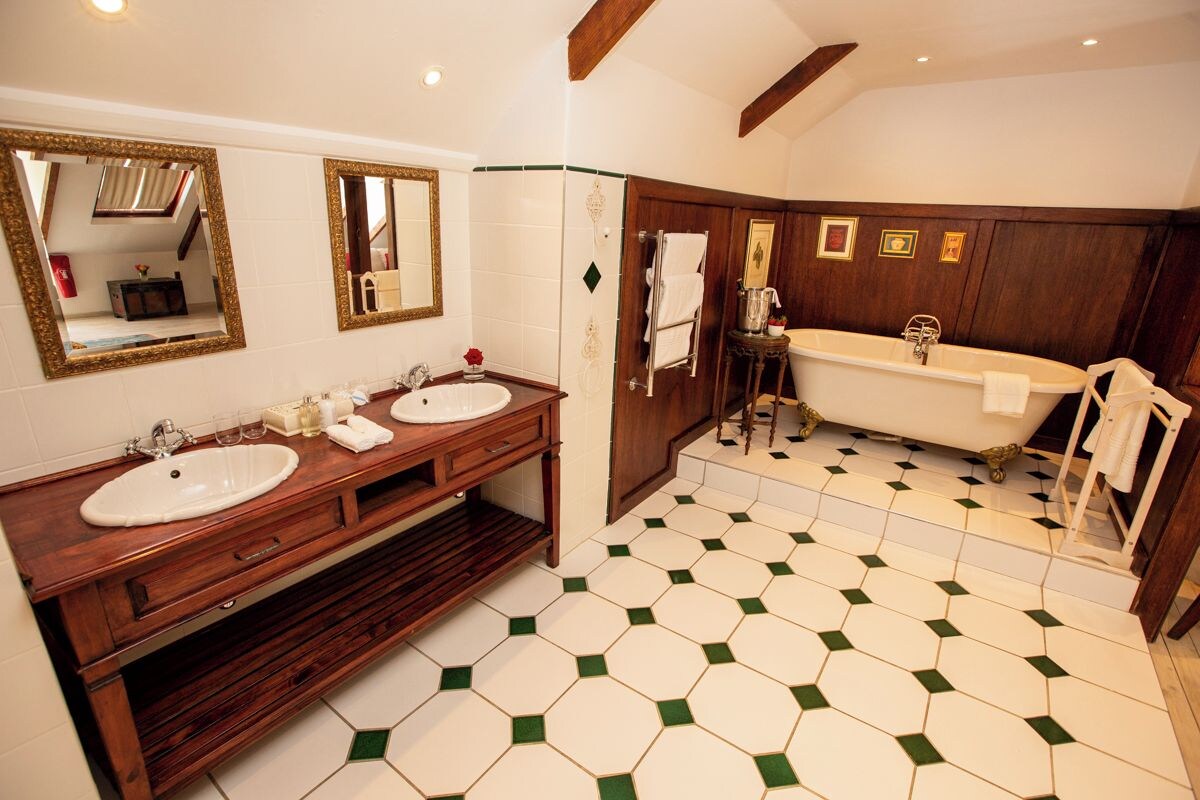 A bathroom with two sinks, a bathtub, and a mirror.