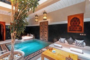 Una piscina techada, sillones reclinables de piscina