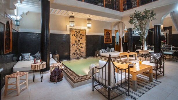 A spacious lounge area with a pool, seating arrangements, and a balcony with a view. - Riad Rodaina & Spa (Marrakech)