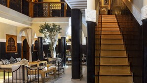 A grand staircase with ornate railings leading to a second-floor balcony. - Riad Rodaina & Spa (Marrakech)