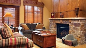 A cozy living room with a fireplace, a sofa, a coffee table, and a pet bed. - Hyatt Residence Club - Main Street Station 2 Bedroom (Breckenridge)