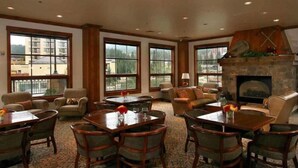 A spacious room with large windows, a fireplace, and multiple seating areas including tables and chairs. - Hyatt Residence Club - Main Street Station 2 Bedroom (Breckenridge)