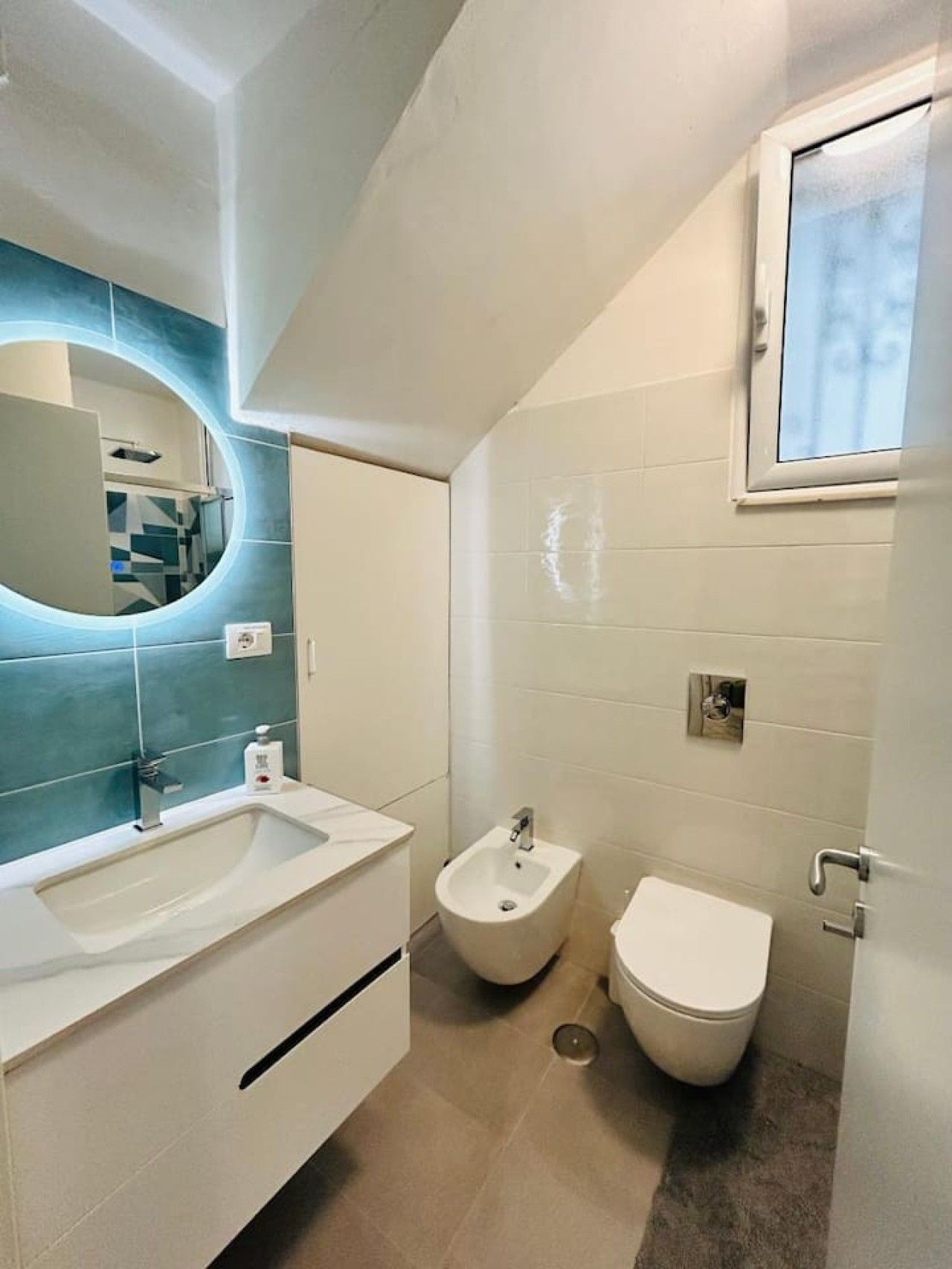 Un bagno con un lavandino bianco, un bidet e un water.