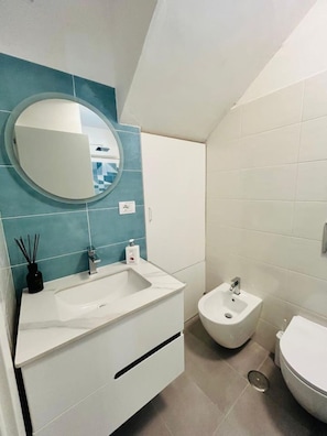 A bathroom with a white sink, a bidet, and a toilet. - Casa Edoardo Two Bedroom Pizzo Calabro (Pizzo)