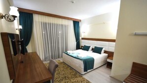 A hotel room with a bed, bedside table, lamp, and a desk. - Can Ilgaz Mountain Resort (Ilgaz)