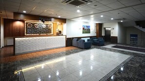 A hotel reception area with a reception desk, seating area, and a staircase. - Can Ilgaz Mountain Resort (Ilgaz)