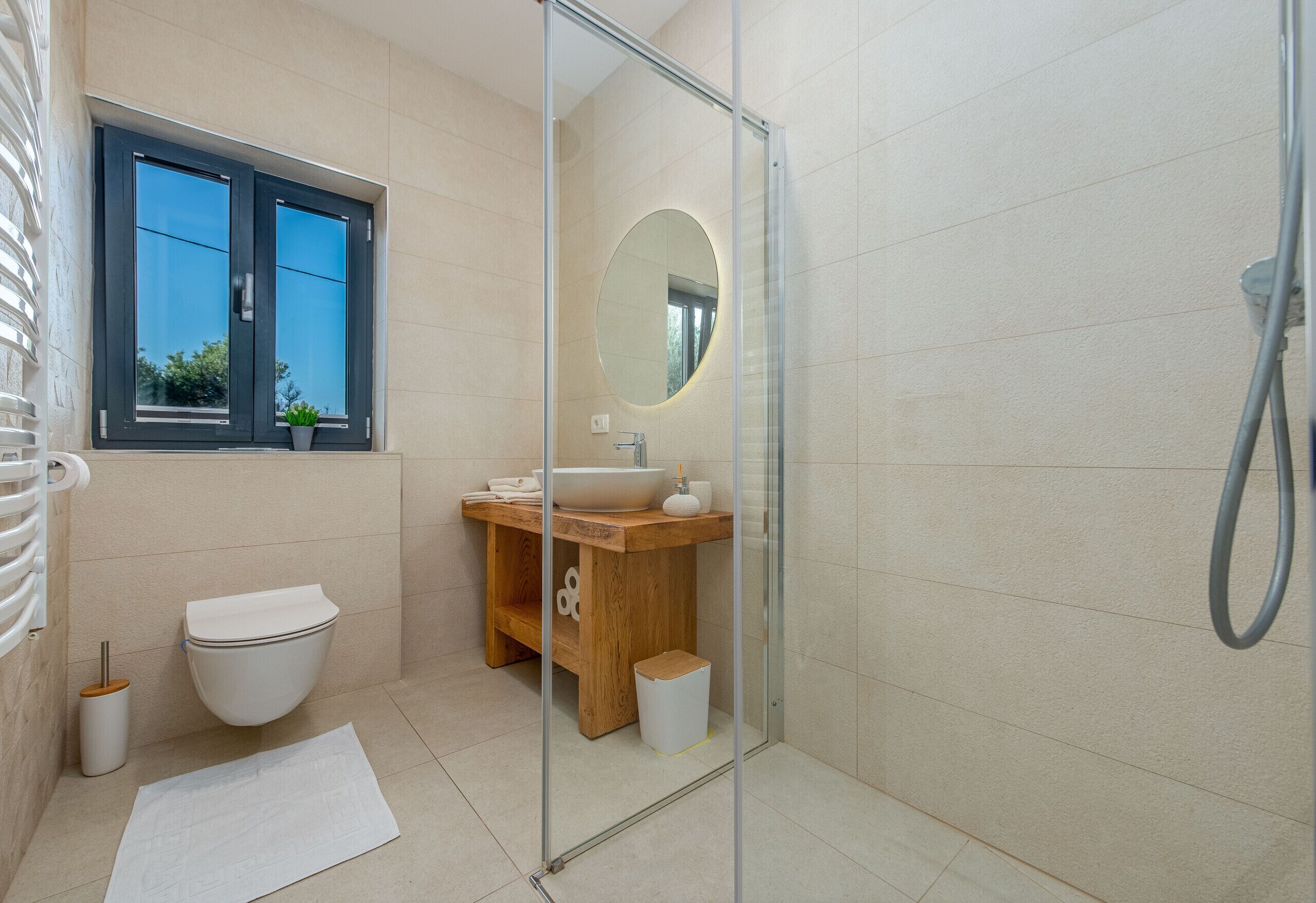 A modern bathroom with a toilet, sink, and shower area.