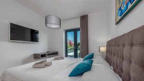 Une chambre d’hôtel moderne dotée d’un grand lit, d’une télévision à écran plat, d’une table de chevet et offrant une vue sur l’extérieur.